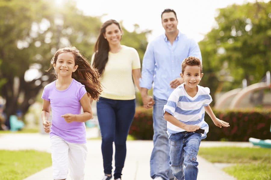 Picture of happy family running through park