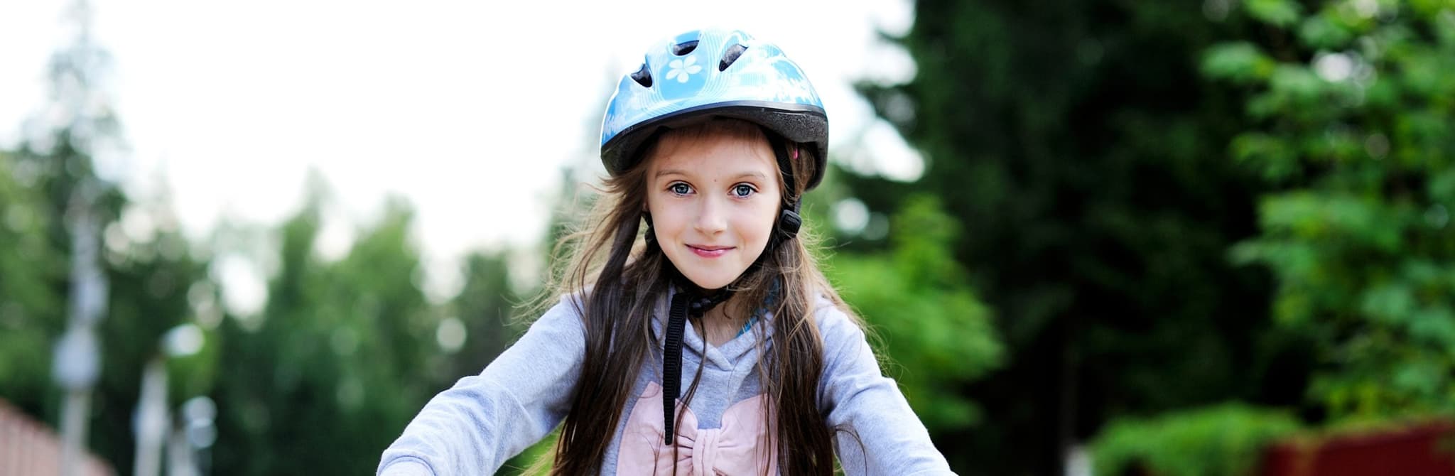happy girl riding bike on side walk