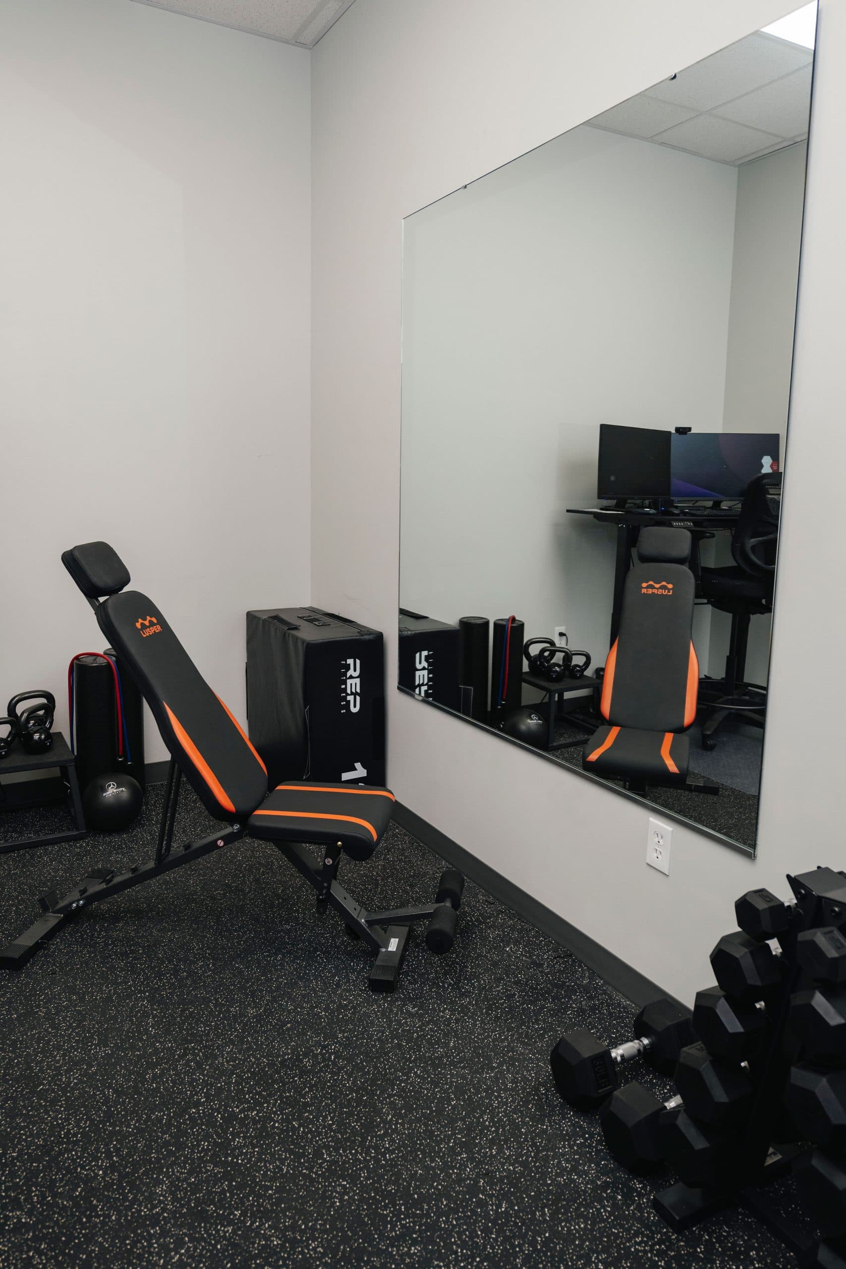Exercise room with weights and benches.