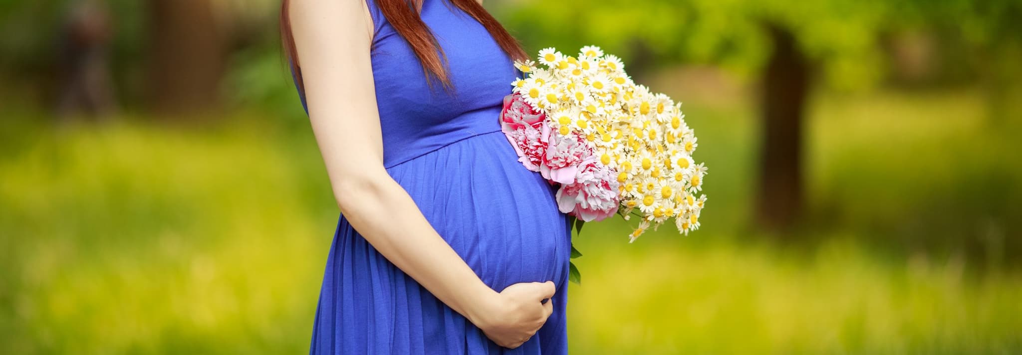 Picture of Pregnant woman in hat holding flowers