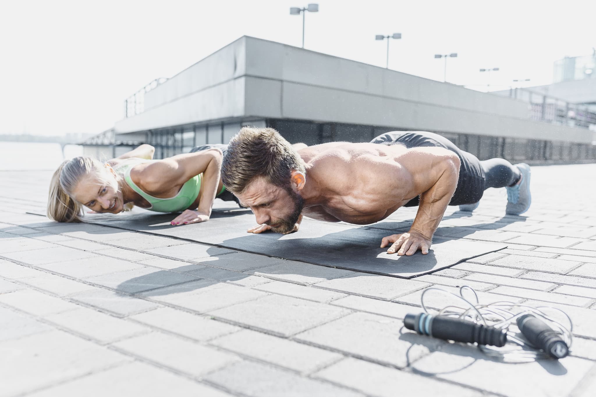 Picture of Fit fitness woman and man doing fitness exercises outdoors at city
